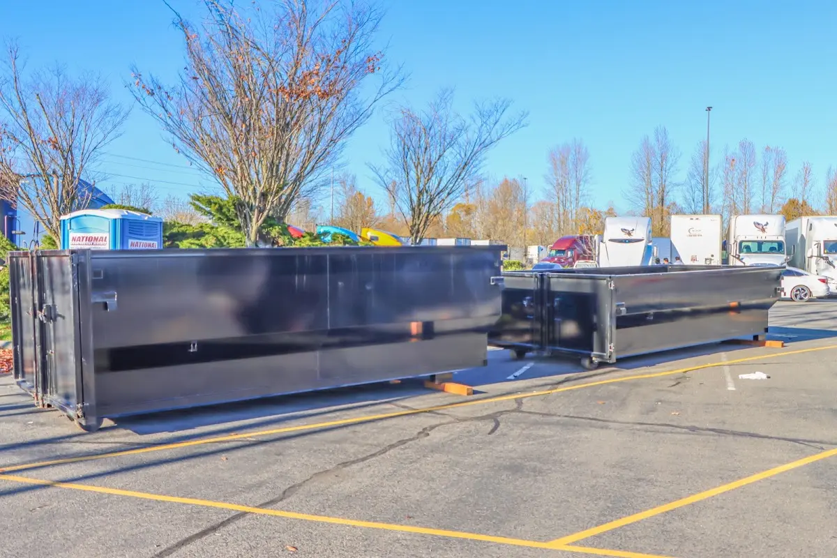 Professional dumpster rental service with roll-off container on residential driveway in Old Forge